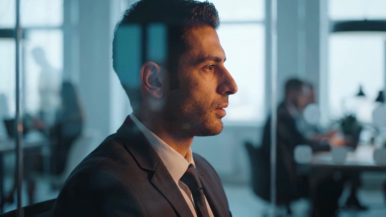 Contemplative Business Professional Engaged in Thoughtful Reflection During a Productive Meeting in a Modern Office Environment with Colleagues Nearby