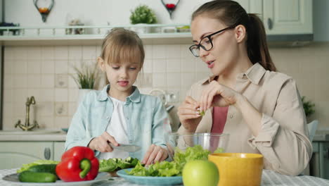 mother and daughter cooking salad together
