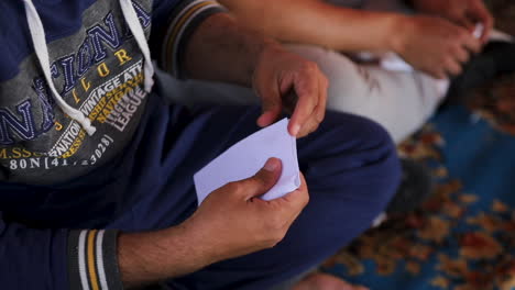 el hombre está doblando un papel.