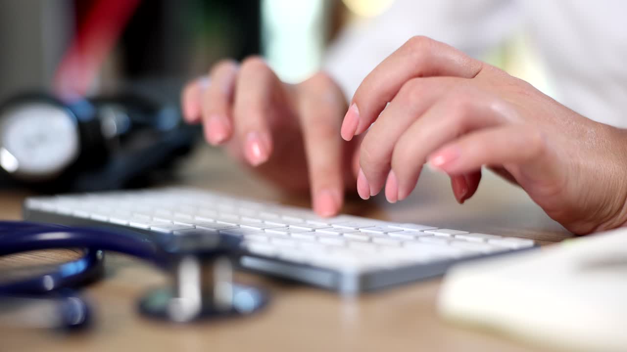 Doctor escribiendo en el teclado con estetoscopio