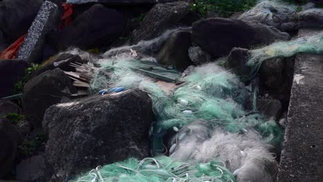 Commercial-fishing-net-abandoned-as-trash-on-ocean-side-rocks