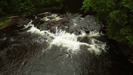 Eine-Drohne,-Die-über-Schäumendes-Wildwasser-Herabsteigt,-Während-Sie-über-Felsige-Stromschnellen-Rast