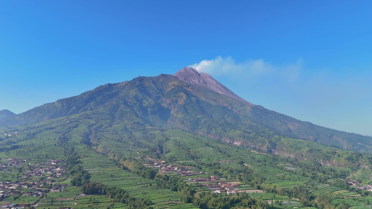 Aerial scenery of volcanic mountain with terraced fields and scattered villages. Mount Merapi Volcano, Indonesia