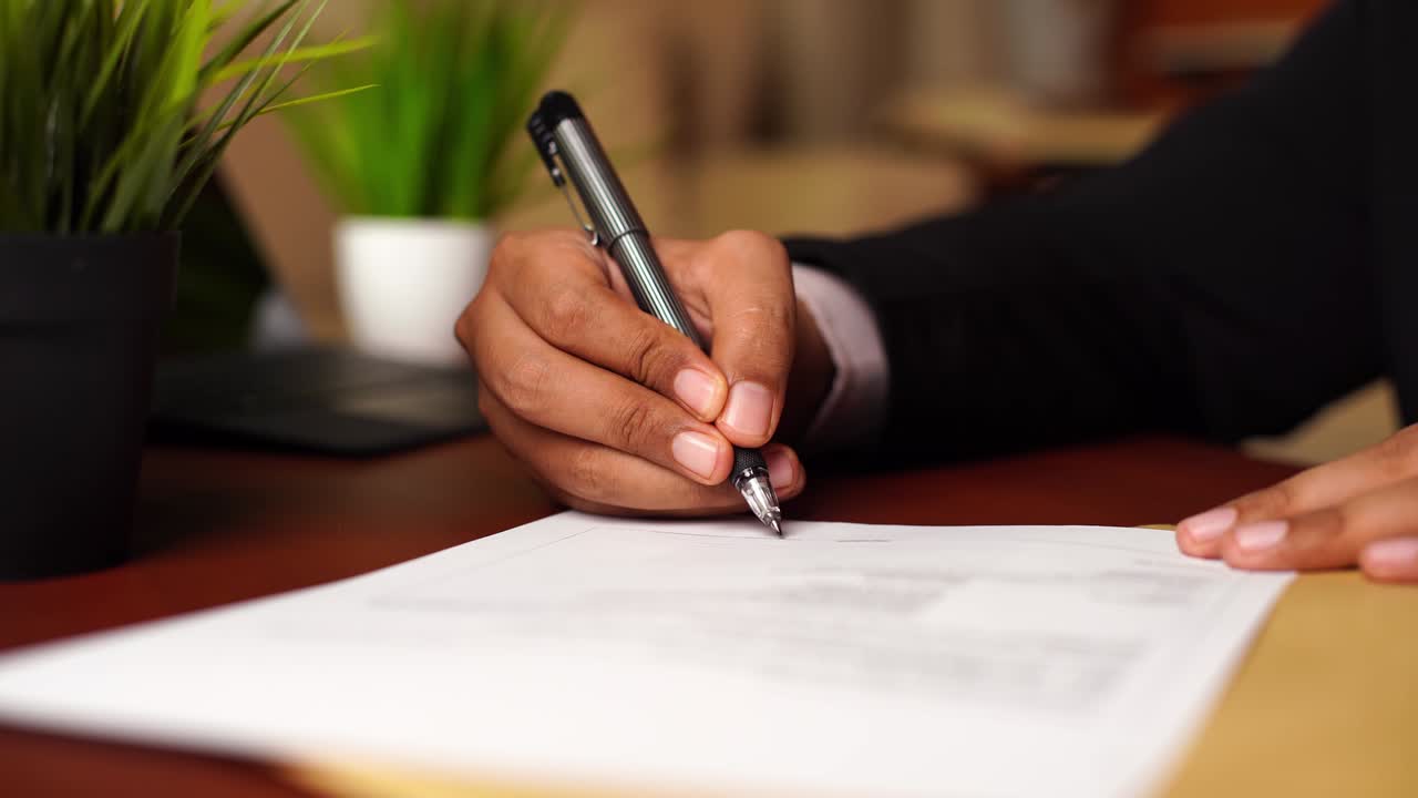 Businessman or CEO or Politician hands signing document or contract or agreement on the office desk.