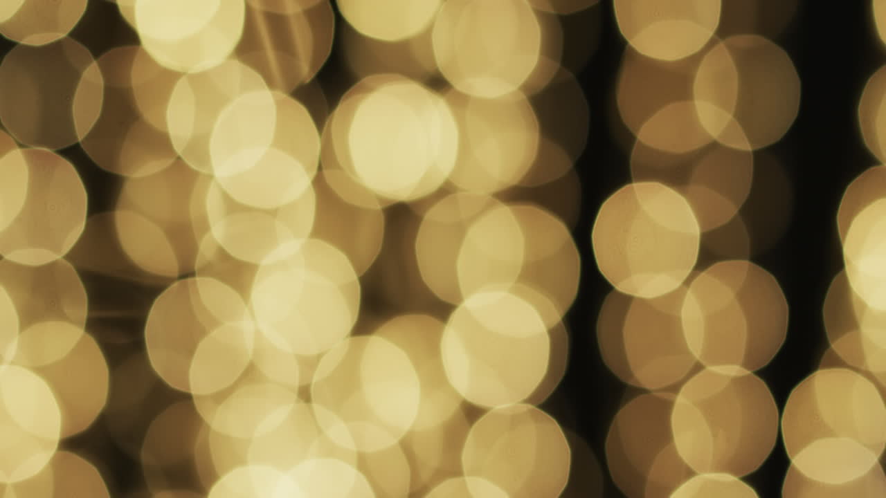 Video of flickering yellow bokeh spots of light with copy space