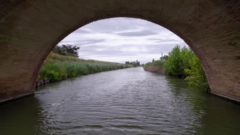 Flotando-Y-Navegando-En-El-Río-Debajo-De-Un-Puente