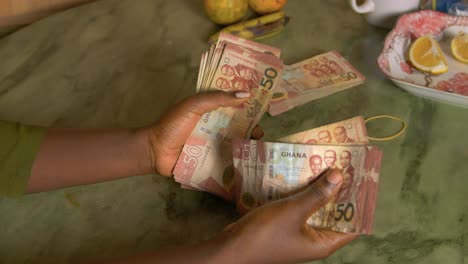 black female woman hand counting ghanaian cedi paper bill from republic of ghana africa