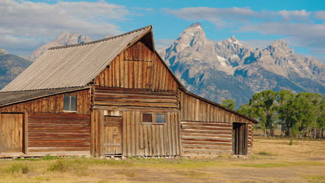 historic wooden barn with grand teton mountains in background