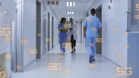 walking in hospital corridor, healthcare professionals with 5g technology animation overlay