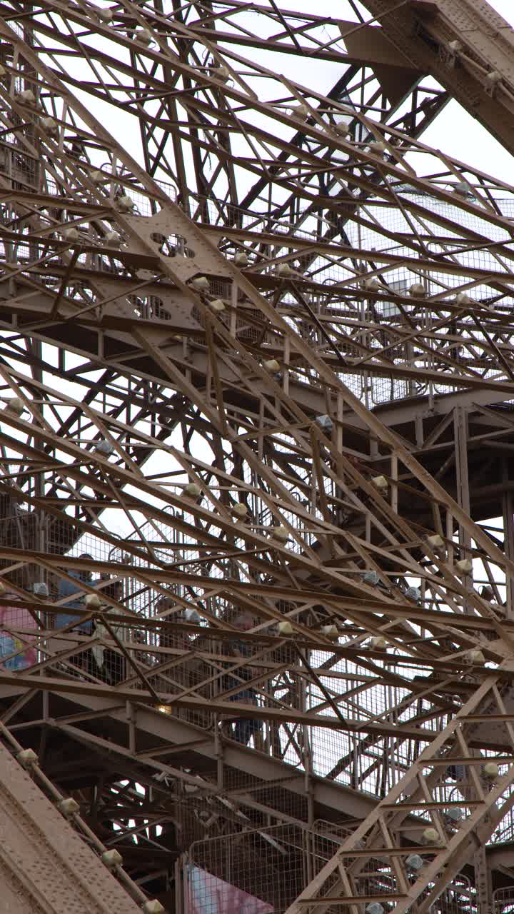 A slow vertical tilt reveals the intricate brown iron lattice and architectural details in Paris