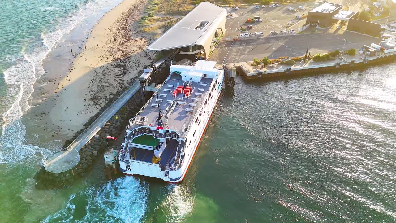 Aerial view of a ferry docking at a terminal in Bellarine, Victoria. Captured in daylight with clear skies and calm waters
