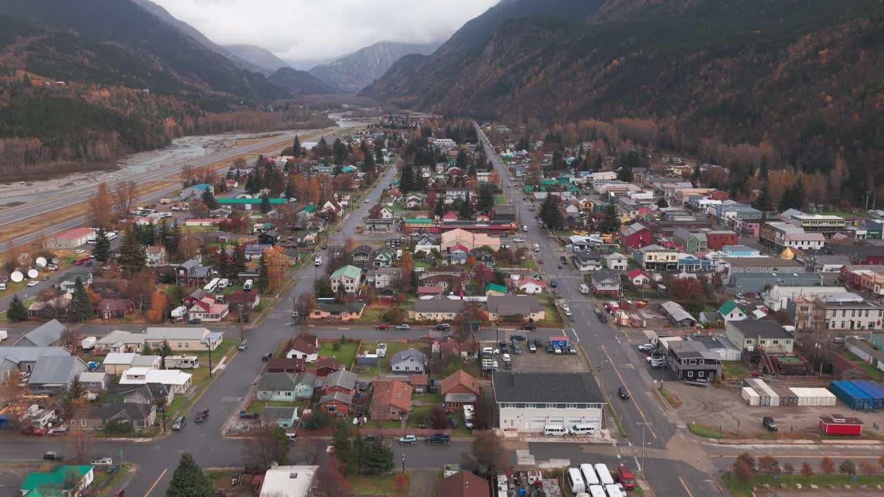 Aerial wide tilting up shot of the historic mining village of Skagway, Alaska with autumn colors. 4K