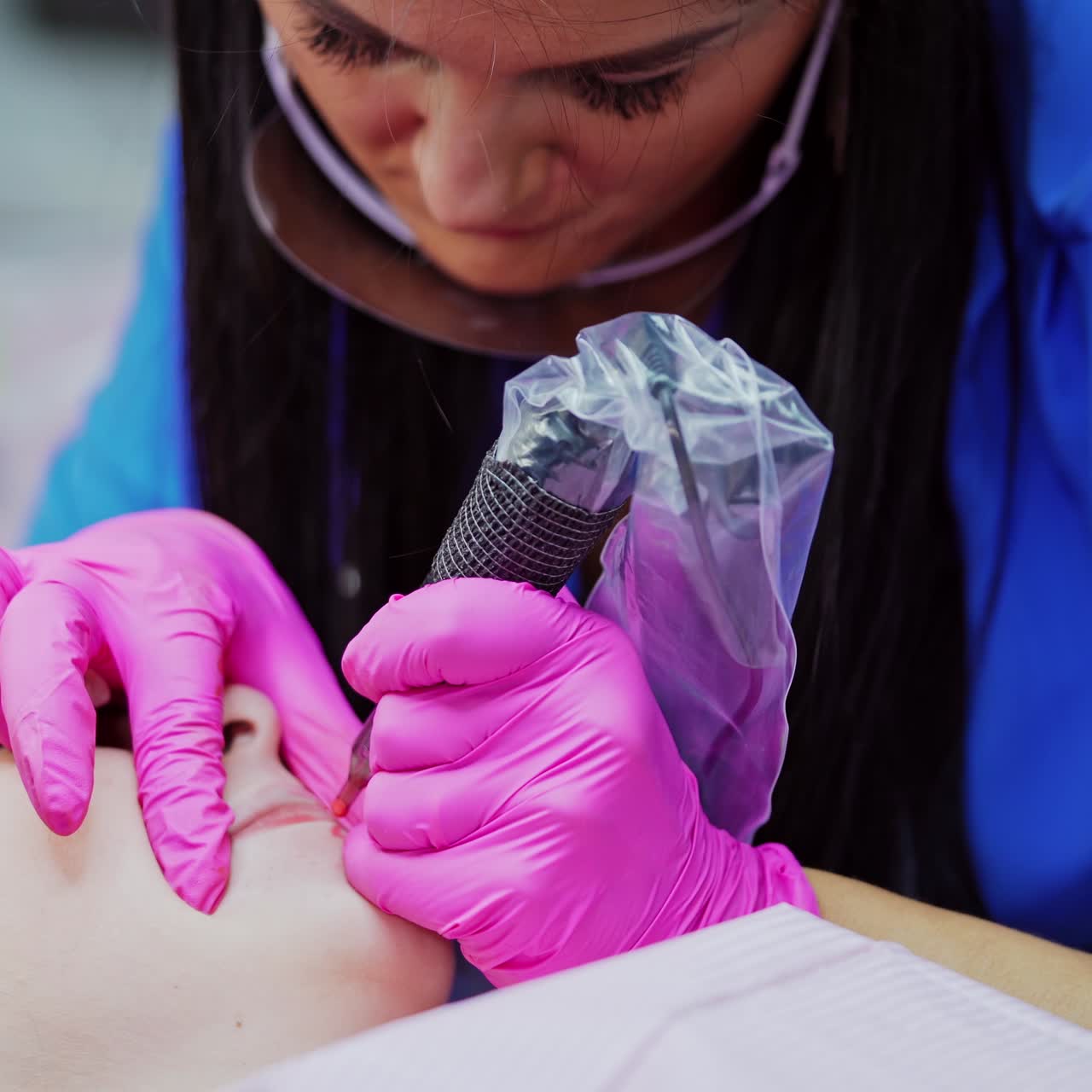 Woman making permanent makeup in salon
