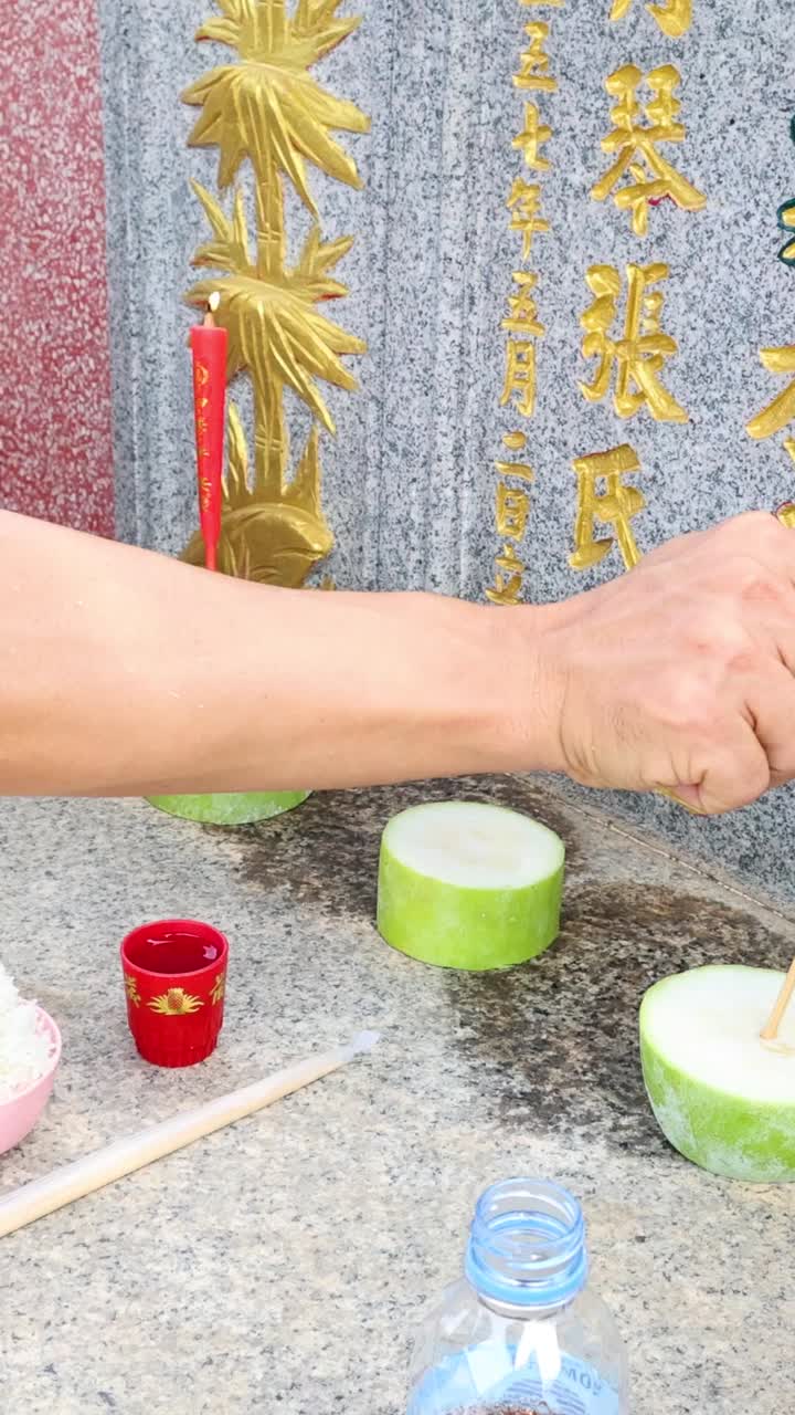 무덤 위에 향을 켜고 있는 사람.