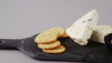 crispy biscuits, cheese and bowl of green olives on tray