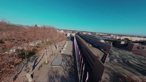 Slowmotion-FPV-diving-shot-of-the-collection-of-flagpoles-at-Le-Corum-in-Montpellier