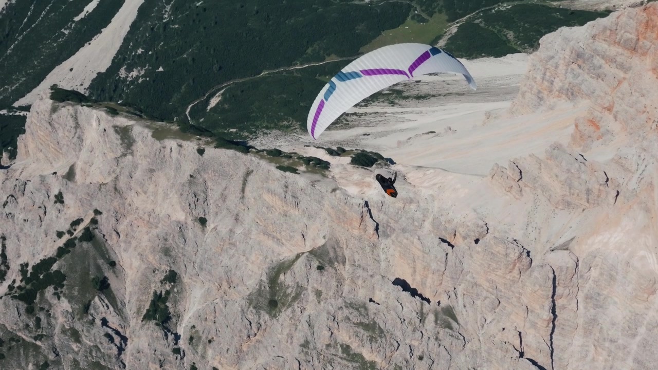Paraglider svever fritt over de fantastiske fjelltoppene i de italienske Dolomittene. – POV-opptak