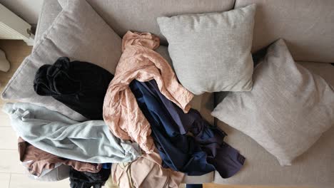 messy clothes pile on sofa