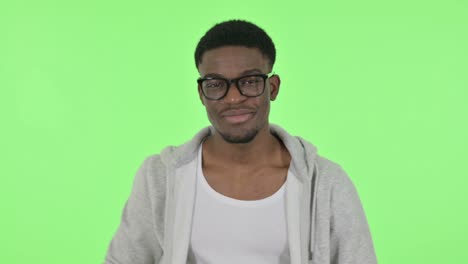 african man pointing with finger, green background