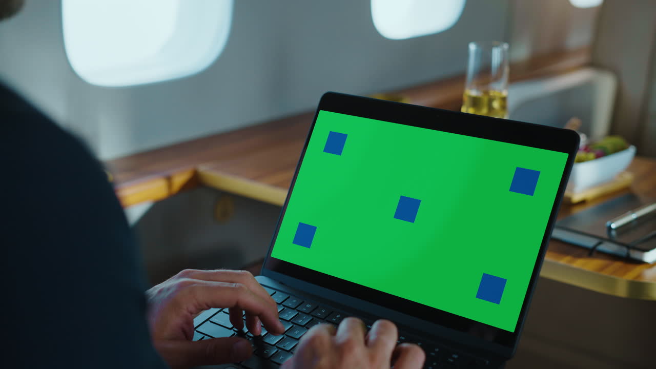 Laptop with green screen in a private jet