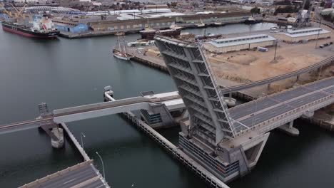 Aerial-view-flying-up-and-over-of-the-Diver-Derrick-opening-bridge-in-Port-Adelaide