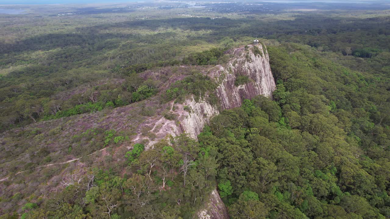 Mount Tinbeerwah's Rugged Cliff With Verdant Forest Vegetation At Tewantin National Park In Queensland. aerial orbiting shot