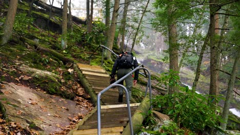 fotógrafo y excursionista subiendo escalones en la naturaleza