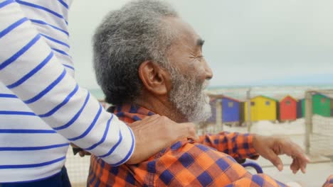 sección media de una mujer afroamericana mayor activa puso su mano en los hombros de un hombre mayor discapacitado 4k