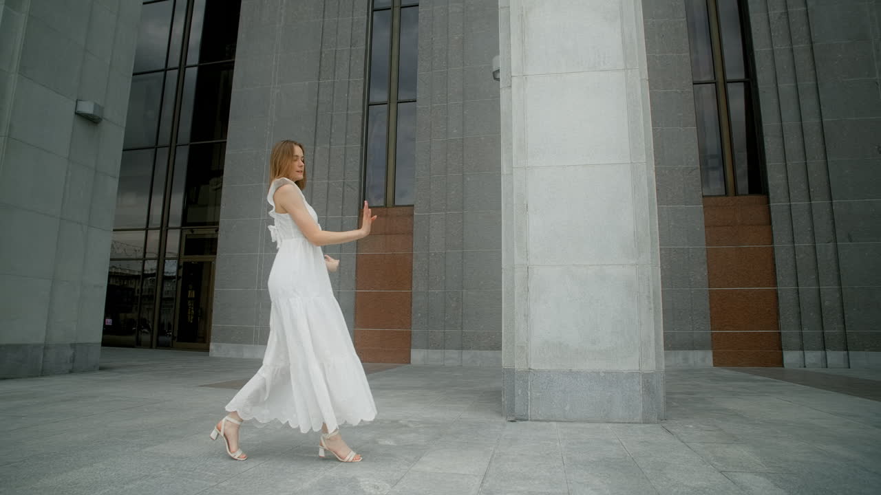 Woman dancing in front of a modern building