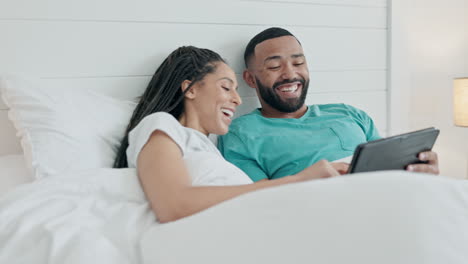 Couple,-tablet-and-laugh-in-bedroom-for-love