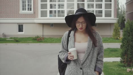 mujer caminando por la calle con café