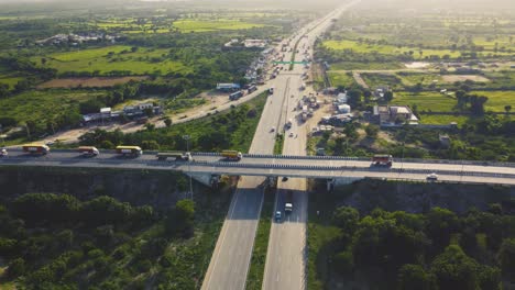 aerial drone view of flyover highway multi-level junction road with moving cars at sunset