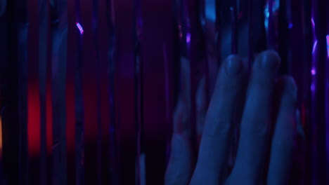 a curtain glitters in the neon lights