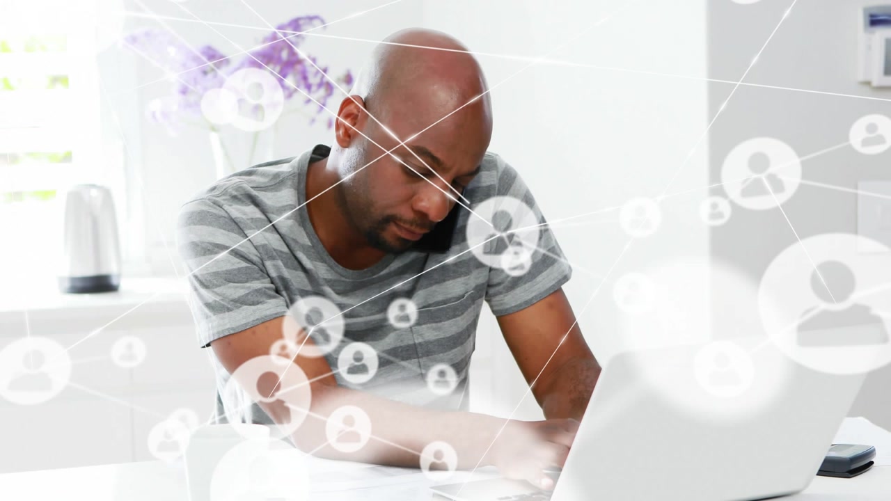 Man sorting finance papers taking call, working on laptop as network overlay expanding across scene