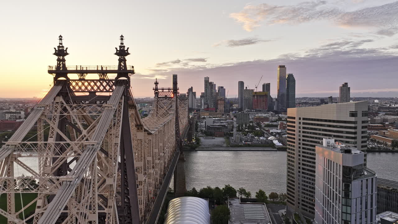 뉴욕 에어리얼 v364 드론이 스보로 다리를 따라 이스트 리버 (east river) 를 가로질러 날아다니며 출퇴근 교통과 즈 (queens) 의 롱아일랜드 시 (long island city) 의 해가 뜨는 도시 풍경을 촬영합니다.