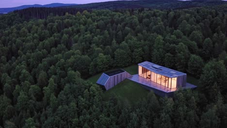 modern house nestled in the forest at dusk