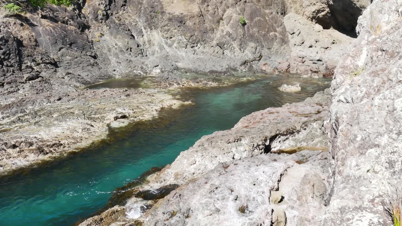 río de montaña cristalino que fluye entre rocas durante el día soleado - bahía de los espíritus, nueva zelanda - tiro panorámico