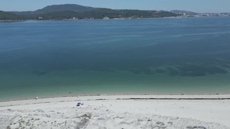la vista aérea captura el movimiento dinámico que se extiende a través, capturando el otro lado de un río en portugal, mientras revela la impresionante extensión de playas paradisíacas debajo