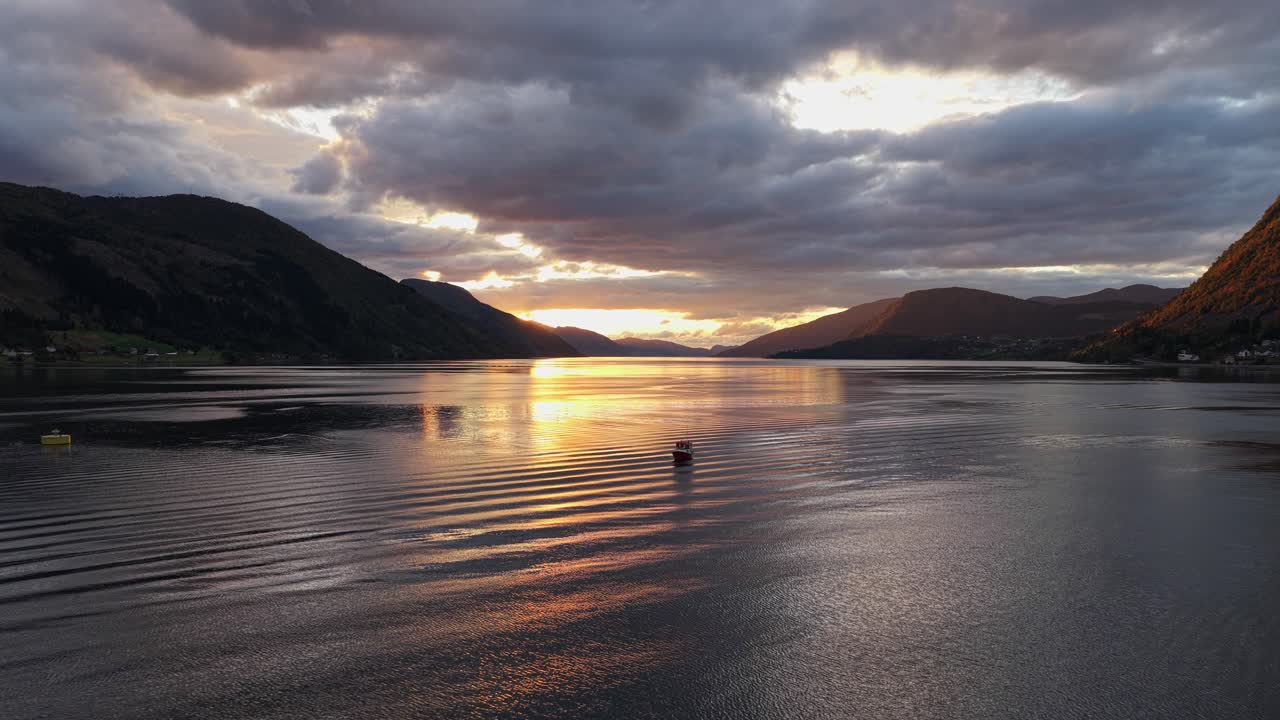 Vista aerea al tramonto di un peschereccio che naviga sul Nordfjord, vicino a Nordfjordeid, Norvegia.
