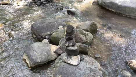 a balanced stone stack by a mountain stream