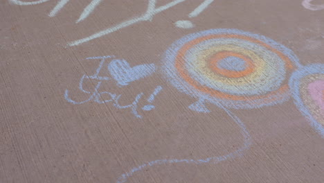 camera drifts over sidewalk chalk revealing messages and art