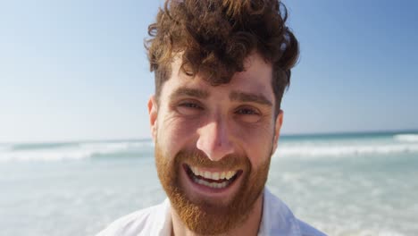 joven feliz mirando a la cámara en la playa 4k