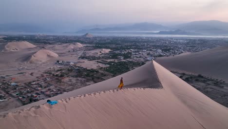 mujer caminando por una duna de arena