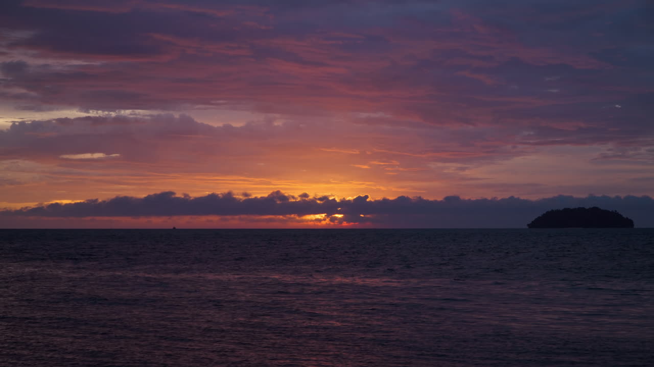 小島がシルエットになった壮大な海の夕焼け。