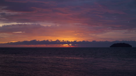 Majestuosa-Puesta-De-Sol-Sobre-El-Horizonte-Del-Mar-Con-Silueta-De-Islote