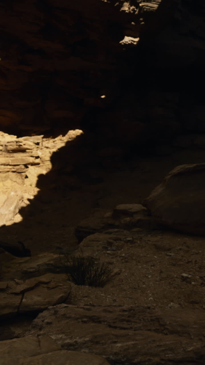 Exploring shadowy rock formations in a secluded desert canyon at sunset