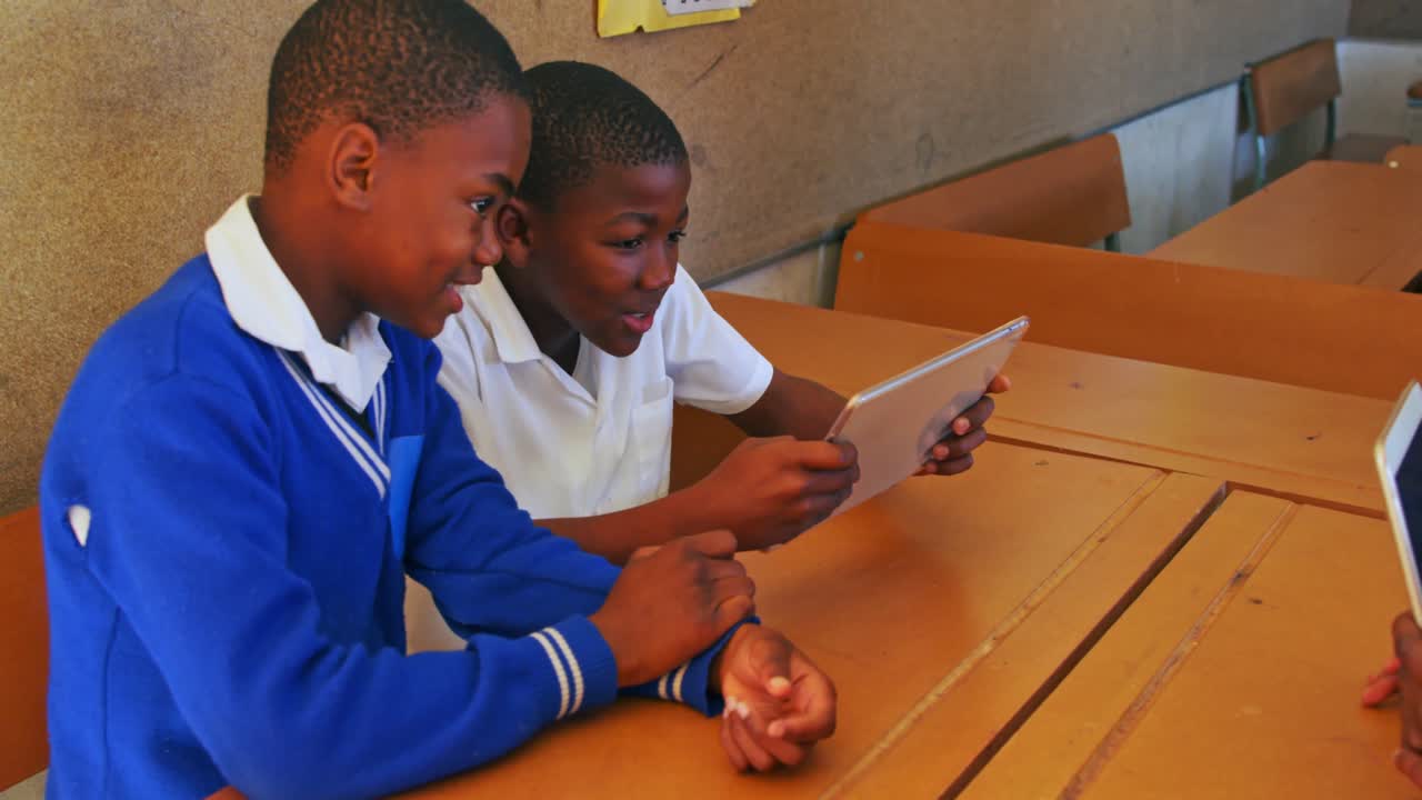 Schoolboys using a tablet during a break at a township school 4k