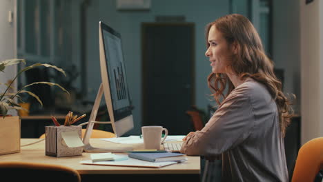 mujer de negocios buscando informe financiero en la computadora por la noche espacio de coworking