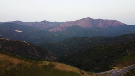 un avión no tripulado se inclina sobre una carretera en las montañas en pico de los reales, estepona, españa
