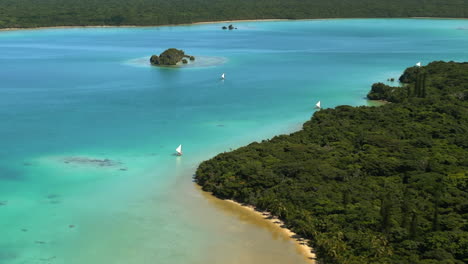 vue aérienne de pirogues naviguant sur les touristes à travers la célèbre baie d'upi de l'île des pins